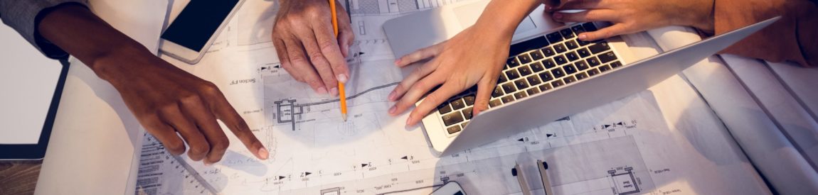 Four architects discussing blueprints in meeting Four architects discussing blueprints in meeting